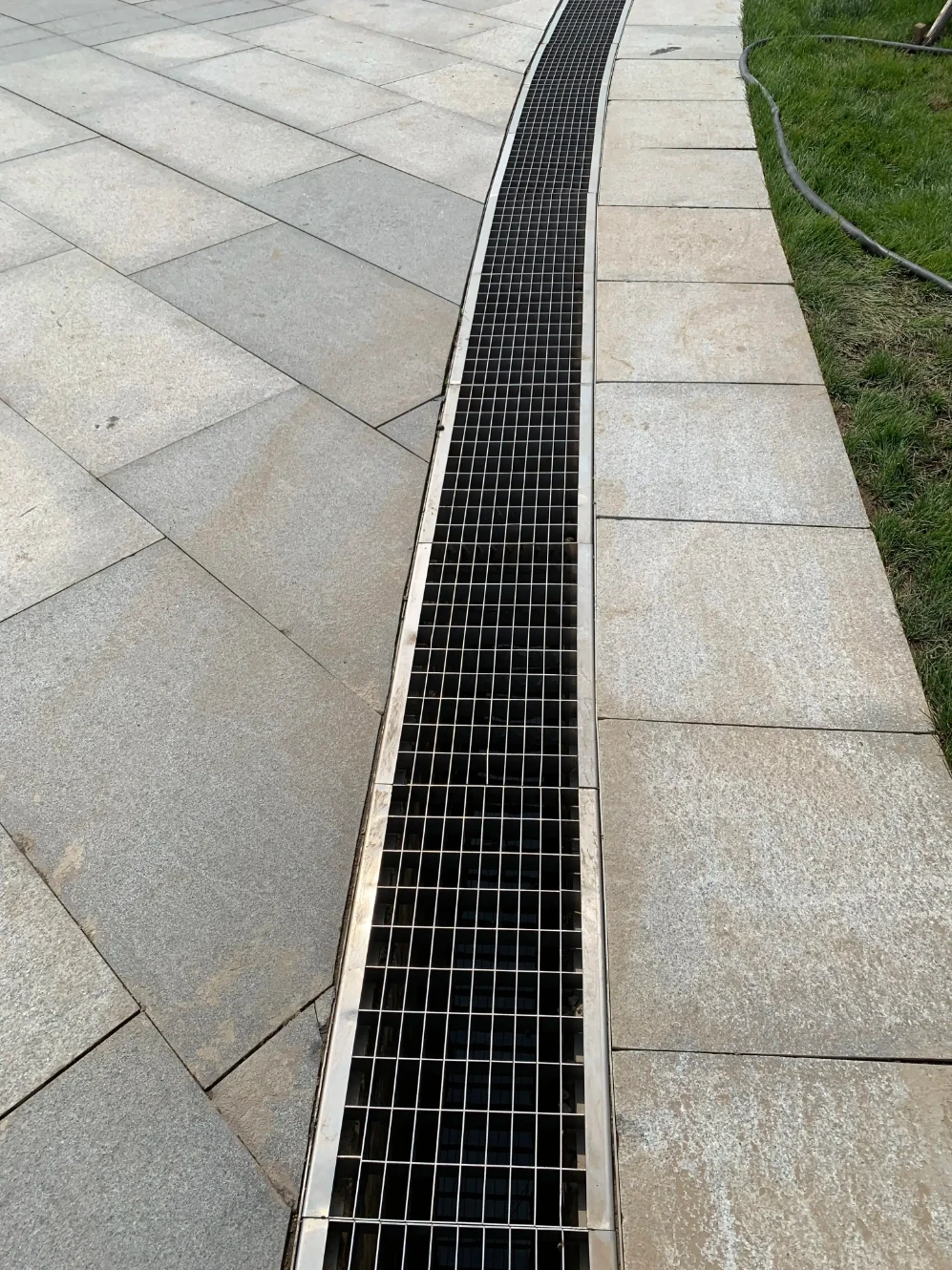 Stainless steel linear drainage channel grate installed in stone paving for outdoor landscaping – ZEMSS China