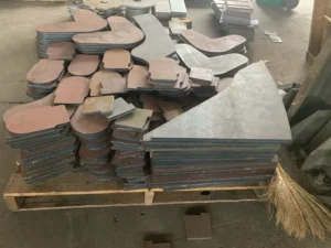 Custom laser cut steel parts in various irregular shapes stacked on pallet – precision cutting by ZEMSS China