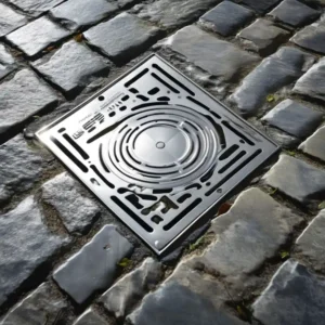 Recessed stainless steel manhole cover with granite paving infill installed in a pedestrian plaza