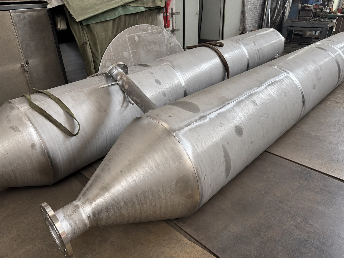 Two long cylindrical process chambers with conical ends in the project workshop
