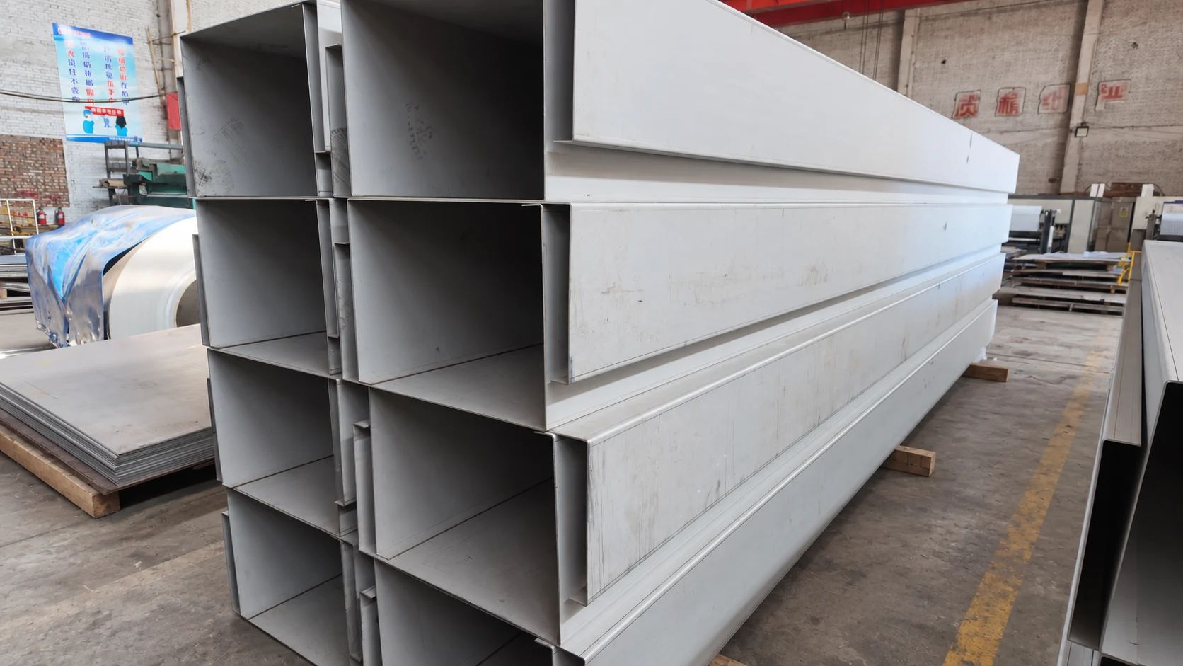 Long channel sections arranged in layers on workshop supports